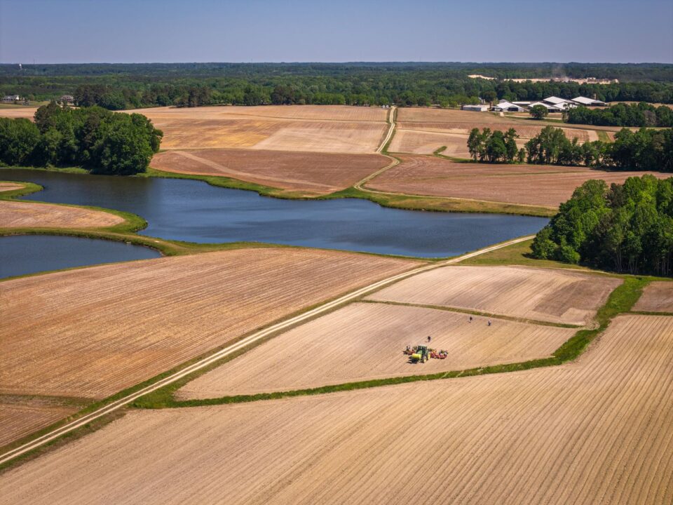Aerial view of flat farm fields and a pond on a coastal plain like Virginia’s Eastern Shore