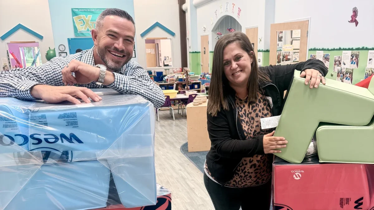 Nick and Amanda Rolon, the new owners of Creative World School in St. Cloud, smiling beside stacks of new soft play blocks inside the school
